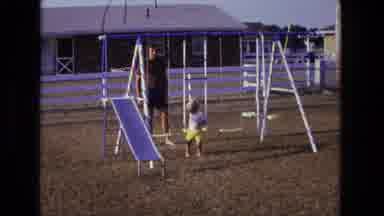 California USA (1975): A Small Child Exits A Swing And Begins To Climb A Sliding