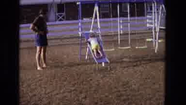 California USA (1975): Little Boy Going Down On A Slide Backwards On A Playground