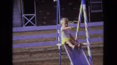 California USA (1975): Young Boy Sits At Top Of Slide And Points At Adult