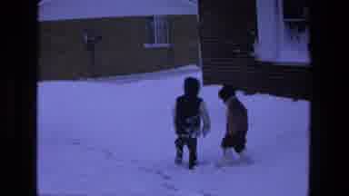 California USA (1975): Two Small Children Walk Around In Snow Outside Of A House