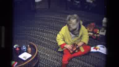 California USA (1975): A Little Boy Sitting On A Rug On The Floor In His Pajamas