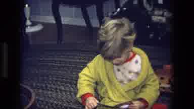 California USA (1975): Young Child Examines A New Toy But Does Not Open It