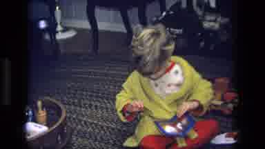 California USA (1975): A Young Girl Sitting On Bvb Floor Opening Food Package