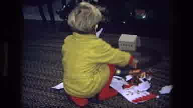 California USA-1975: Boy In Yellow Shirt And Red Pants Playing With Train Set