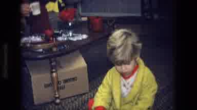 California USA (1975): A Young Boy In A Yellow Dressing Gown Plays On The Floor