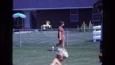 California USA (1975): Woman Wearing Red Shorts Walks On Green Grass On Sunny Day