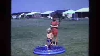 California USA (1975): Two Suburban Children Play In Backyard Inflatable Pool With