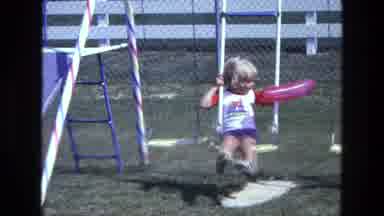 California USA (1975): Child Enjoying Time Outside Playing On Swing Set With