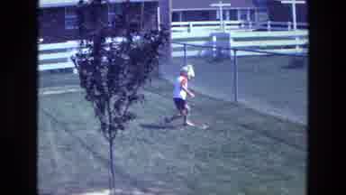 California USA (1975): Young Boy At Playground Picking An Object Up Off The Ground
