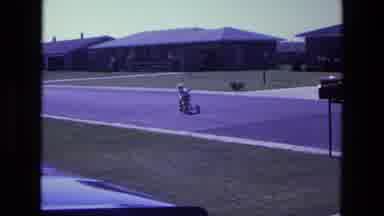 California USA (1975): Child On Trike Riding Along Road