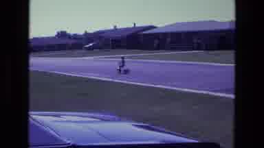 California USA (1975): Boy Riding Tricycle In The Street Of A Quiet Neighborhood