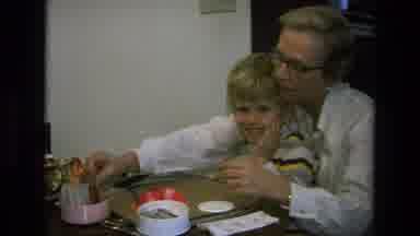 California USA (1975): Lady With Her Son On Her Lap Playing A Game With Cards At A