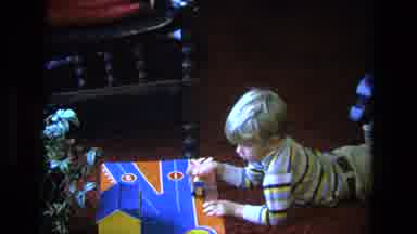 California USA (1975): Seven Year Old Boy Plays With A Toy Car In The Living Room