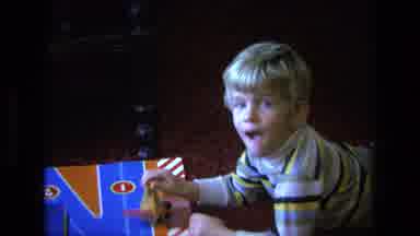 California USA (1975): Young White Blond Boy Playing With Car On Board Gets