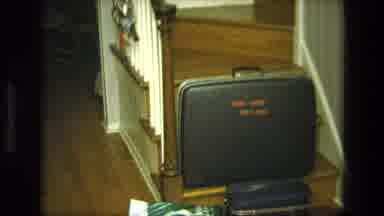 California USA (1975): A View Of Suitcase And Boy Resting On Furniture