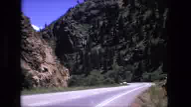 Fort Wayne Indiana (1976): Cars Driving Along An Open Mountain Road On A Sunny Day