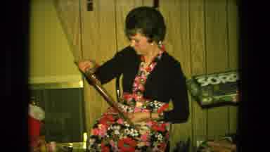 Fort Wayne Indiana (1976): Woman Wearing Black Sweater Places Wrapped Christmas