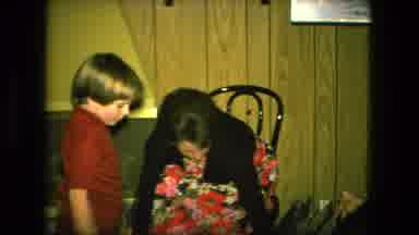 Fort Wayne Indiana (1976): Woman Wearing Black Shirt Helps Boy Wearing Red Shirt