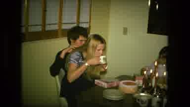 Fort Wayne Indiana (1976): Three People Gathered By A Dining Room Table For A
