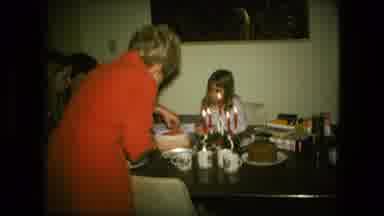 Fort Wayne Indiana (1976): Woman Wearing Red Dress Cuts Small White Cake Sitting