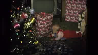 Fort Wayne Indiana (1976): Baby Wearing Red Overalls Looks At Large Gift Box Under