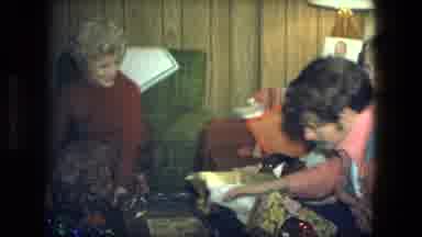 Fort Wayne Indiana (1976): Man Sitting On A Couch Unwrapping Christmas Gifts And