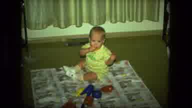 Fort Wayne Indiana (1976): Baby Sitting On Floor Of A Room With A Toy In Mouth