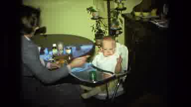 Fort Wayne Indiana (1976): Mom Sitting At A Table With Baby In High Chair Feeding