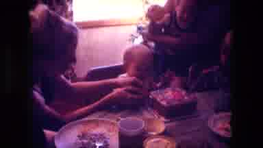Fort Wayne Indiana (1976): A Mother Helps A Small Child Eat A Cake At A Birthday