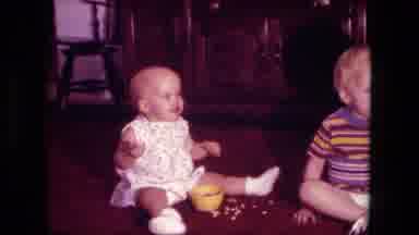 Fort Wayne Indiana (1976): Baby Sits On Floor Eating Dry Cereal As Older Toddler