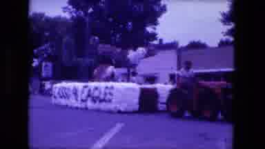 Fort Wayne Indiana (1976): A Tractor Pulling A Float In A Homecoming Parade Says