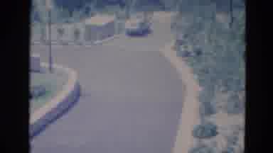 Minnesota (1976): Light Blue Car Parked On Street Lined With Green Trees On A