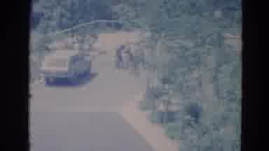 Minnesota (1976): Car Parked On A Dirt Street Surrounded By Trees And Some