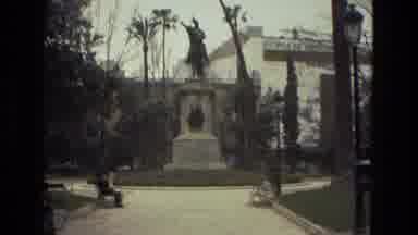 Barcelona Spain (1978): A Tall Statue In An Area With Trees And Buildings