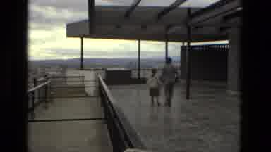 Barcelona Spain (1978): Man Wearing Grey Suit Runs With Girl Wearing White Sweater