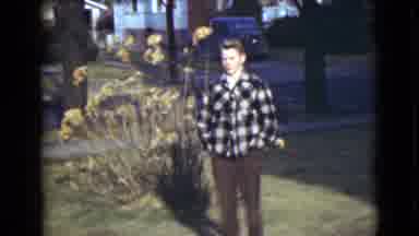 Alaska (1946): Young Man Standing In Yard Of Neighborhood By A Tall Plant Fall