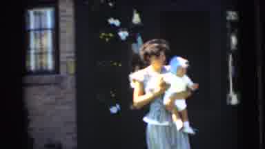 Chatham New Jersey (1951): Woman Wearing Tan Dress Sits And Holds Baby Wearing