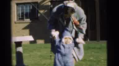 Chatham New Jersey (1951): Woman Helping A Baby In A Puffy Snowsuit Learn How To
