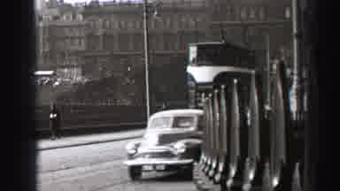EDINBOURGH SCOTLAND-1952: A Trolley Moves Through A City Street As Old Cars Pass