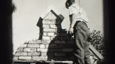 EDINBOURGH SCOTLAND-1952: Workers Building A Brick Chimney On A Roof