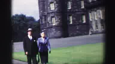 EDINBOURGH SCOTLAND-1952: A Man And Woman Walking Outside A Historic Castle