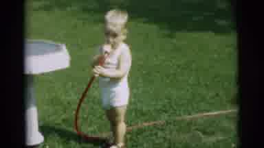 Pennington New Jersey (1954): Small Child Drinks Out Of Garden Hose While Filling