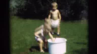 Pennington New Jersey (1954): Toddler Wearing White Shirt Puts Red Hose Into White