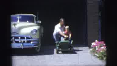 Pennington New Jersey (1955): Man And Child Riding On Small Play Car Down The