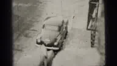 New York City (1956): Car Drives Away And Lady Smirks At Camera