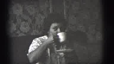 New York City (1956): Woman Sitting Down Looking Up While Sipping A Drink In A