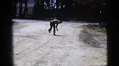New York City (1956): A Man Picks Up A Stone On A Road And Gestures To Throw It