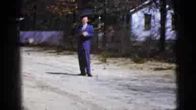 New York City (1956): A Man Wearing A Blue Suit Is Standing Outside Next To A