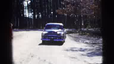 New York City (1956): Person Drives Away In The Green Car As Others Outside The