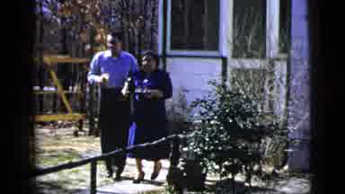 New York City (1956): Middle Aged Woman Serves Beverages Outdoors To A Couple Of